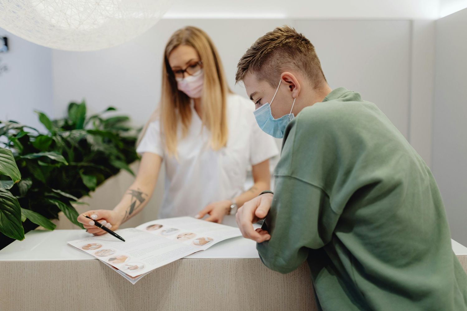 Staff assisting a patient with Humana podiatrist services in Cypress using a brochure, offering personalized foot care consultation in a welcoming clinic.