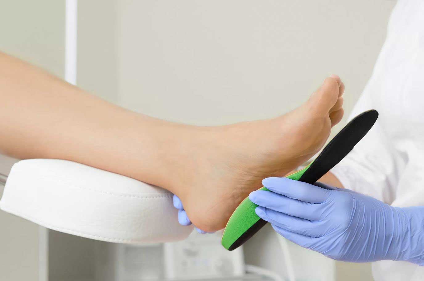 Foot doctor in Cypress Tx fitting a custom orthotics to a patients feet