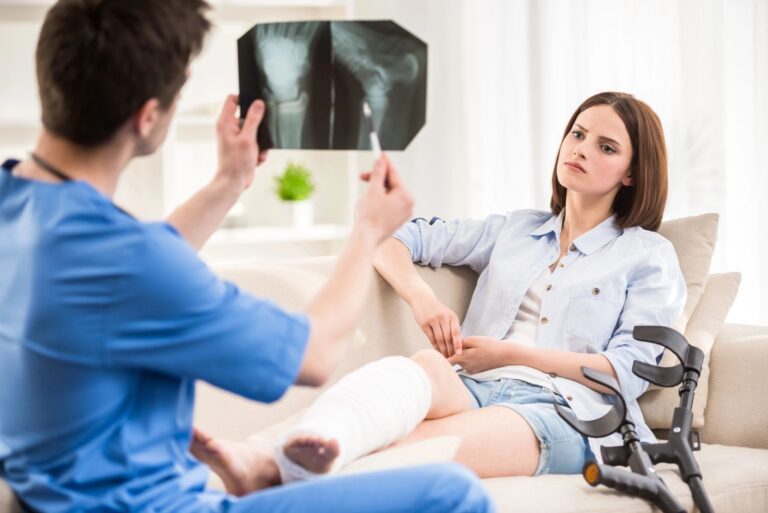 A doctor shows a patient an X-ray of her broken ankle at an urgent care for foot pain in Houston.