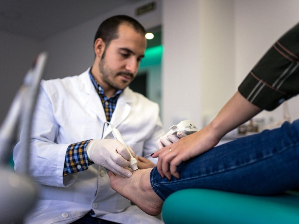 A foot specialist doctor treating a patient’s foot disorder.