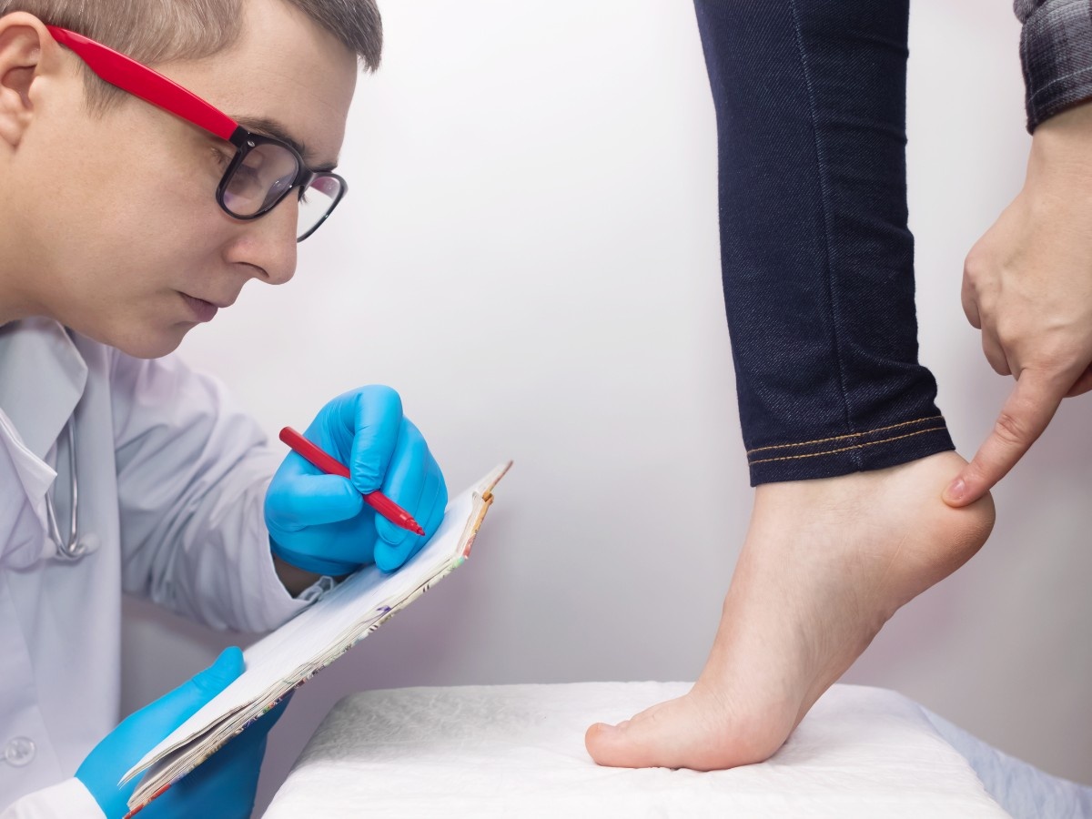 A heel pain treatment specialist in Lincoln Green Place examining a patient’s heel pain and taking medical notes.