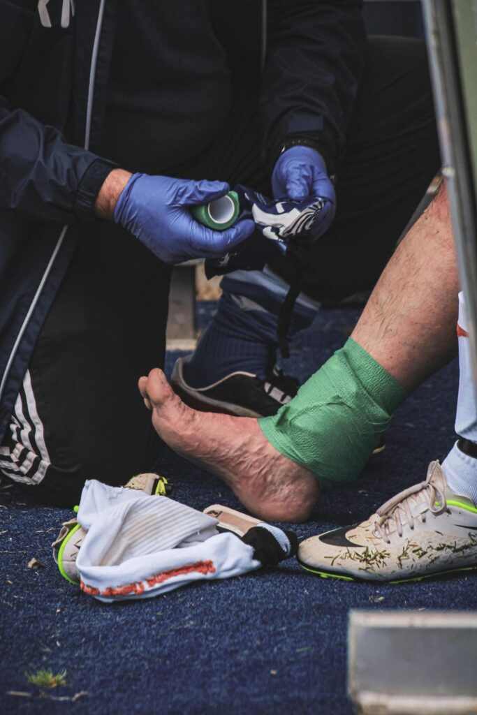 A medical professional bandages a patient's sprained ankle, providing expert care at urgent care for ankle sprain in Houston.