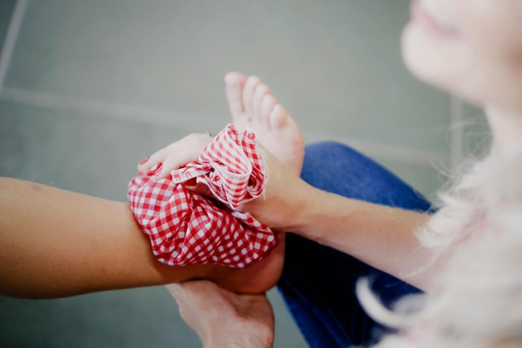 A patient applies an ice pack to a painful heel, a common practice before seeking urgent care for heel pain in Houston.