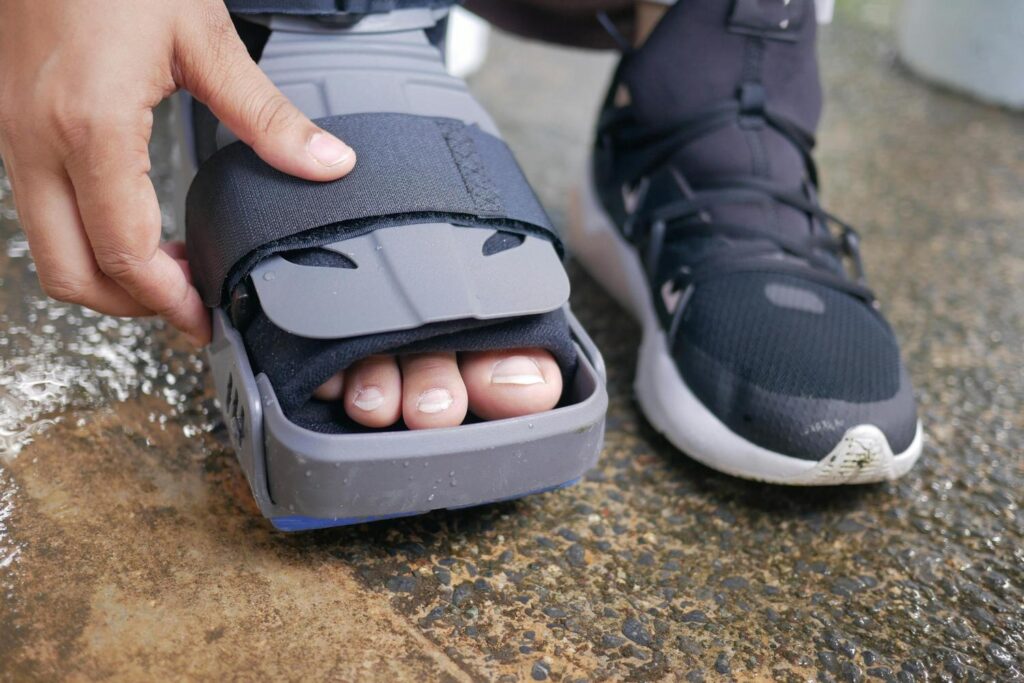 A patient wears a medical boot for their injury, a common condition seen at urgent care for foot pain in Houston.