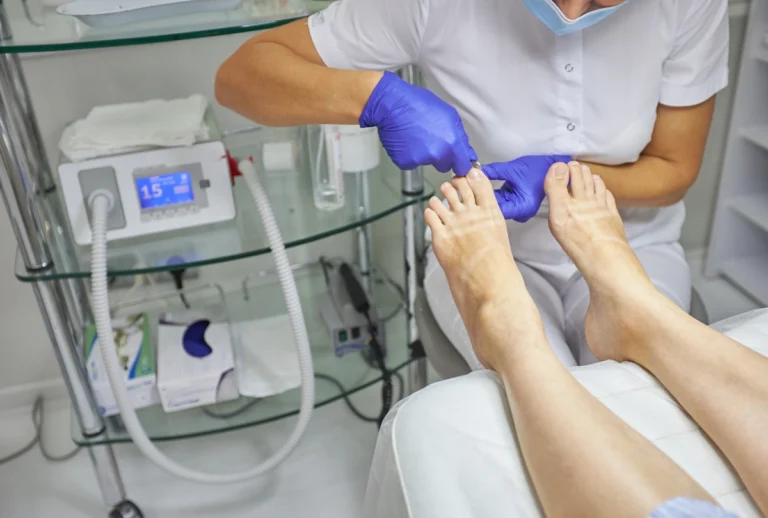 DPM Doctor Cypress provides hygienic foot care. Technician performs pedicure in clean clinic with advanced equipment.