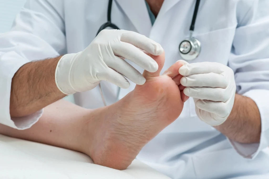 Foot doctor Houston performs clinical toe exam to check for infection, injury, or diabetic foot care in medical setting.