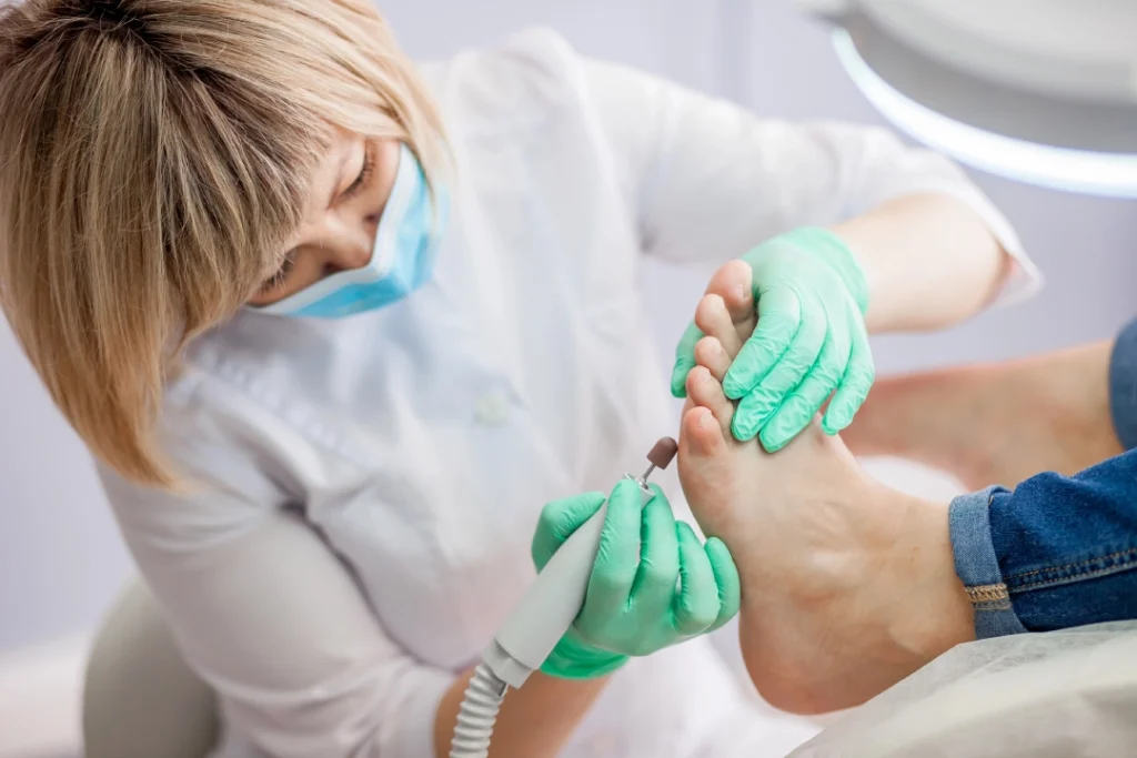 Foot specialist doctor Houston performs professional nail care using electric drill in clean, comfortable clinic setting.