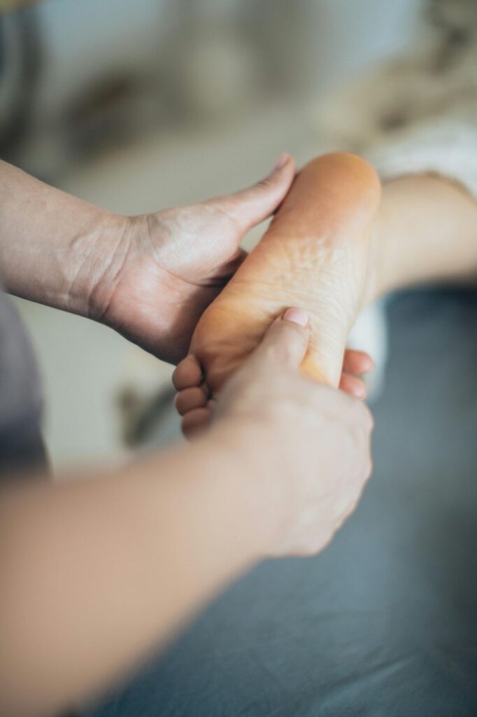 Podiatrist examining a patient’s foot in a clinic, representing Medicare-covered podiatry and toenail care services in Cypress.