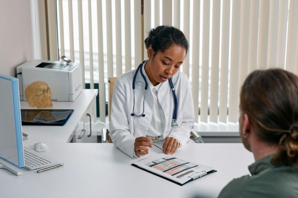 Podiatrist in Cypress reviewing Medicare-covered foot care plan with patient during clinic consultation in modern medical office.
