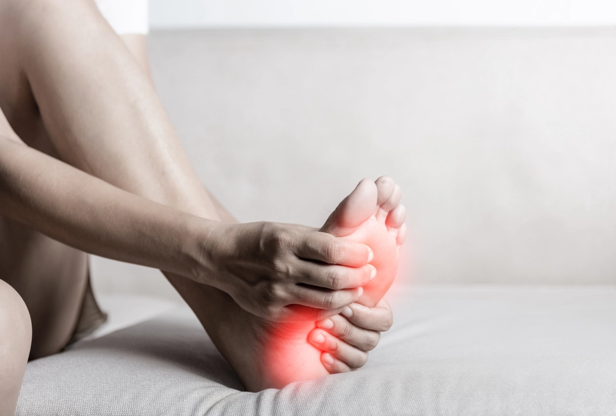 Toe Doctors Cypress help relieve foot pain and inflammation. Patient shown holding sore foot with red pain indicator.