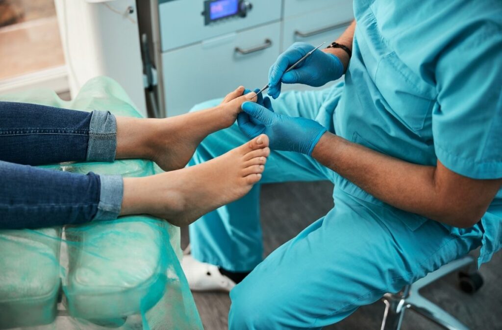 Foot doctor walk in clinic performing toenail care with metal tool during patient exam in sterile medical environment.