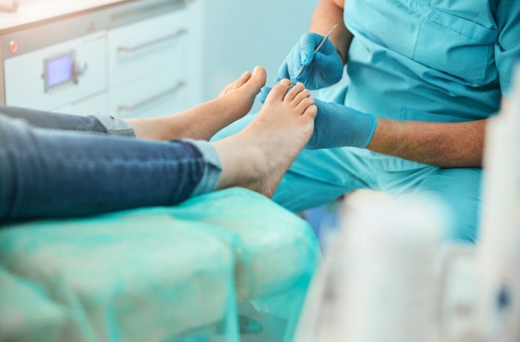 Walk in foot doctor using precision tool to treat toenail issues during patient visit in professional podiatry clinic.