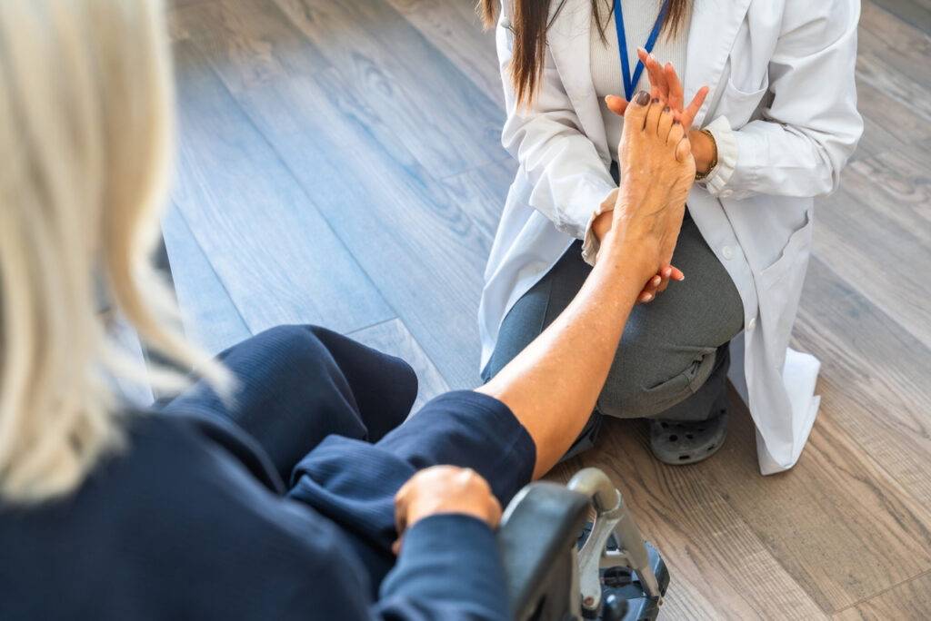 A dpm doctor cypress examines a patient's foot during a consultation for mobility issues and crutch support in a clinic.