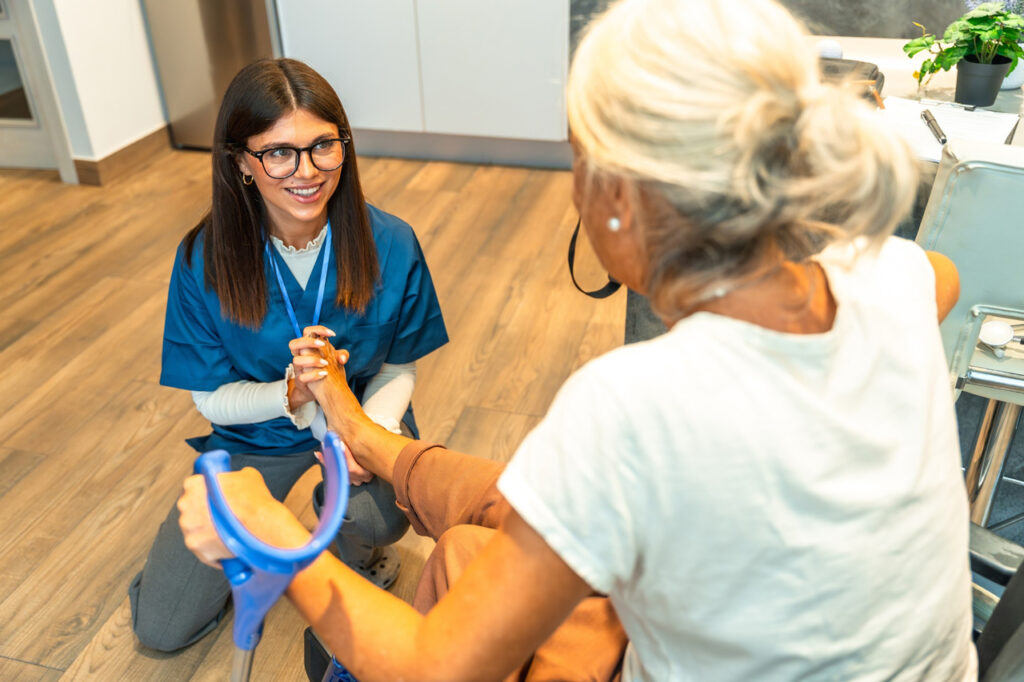 Female dpm doctor cypress performing a diagnostic foot exam on an elderly patient in a wheelchair at a medical office.