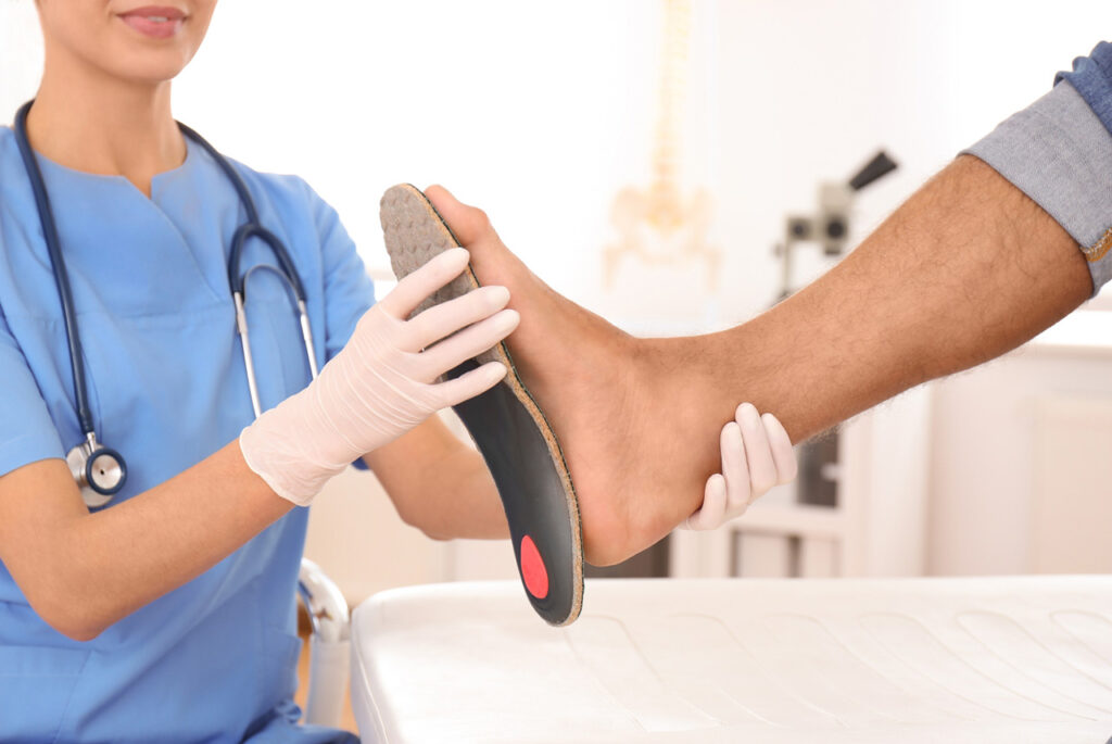 A specialist at a Walk In Podiatrist Cypress clinic examines a patient’s foot with a custom orthopedic insole.