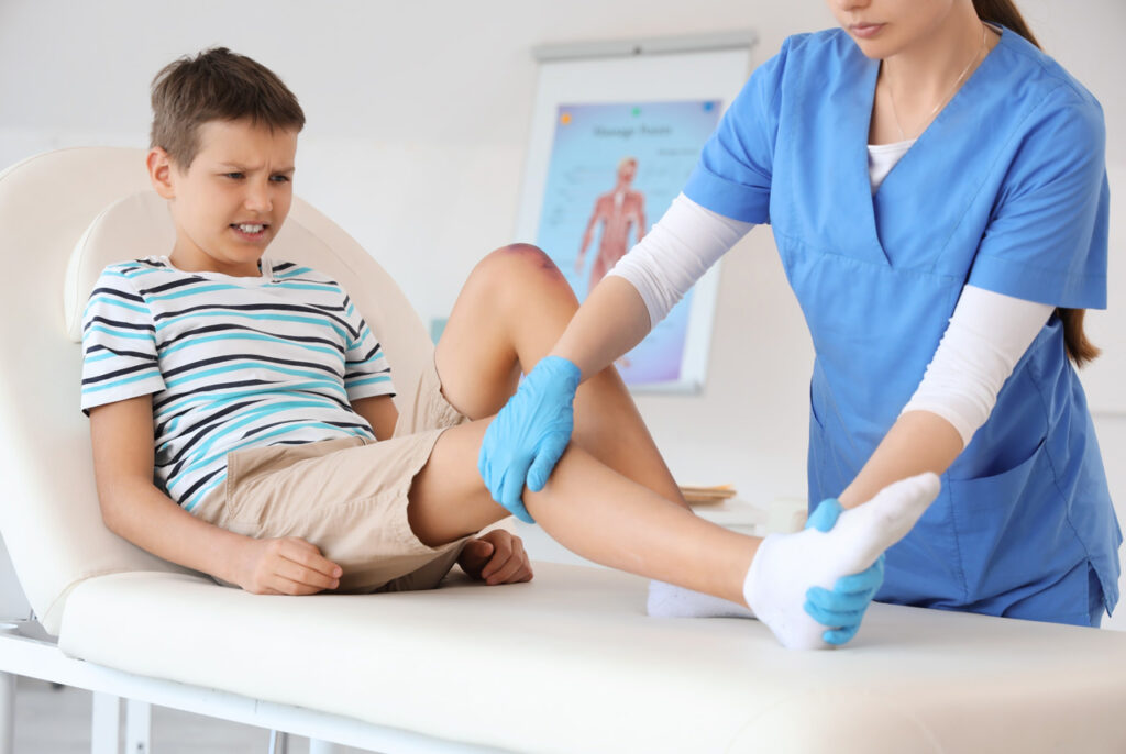 Young boy receiving a pediatric foot and leg injury examination from a professional Foot and Ankle Doctor Cypress.