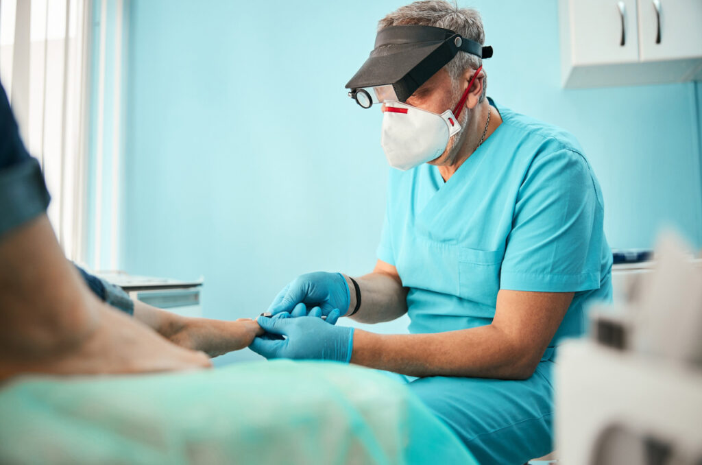 Experienced specialist at Podiatry Clinic Cypress performing a detailed foot examination using professional magnifying gear.