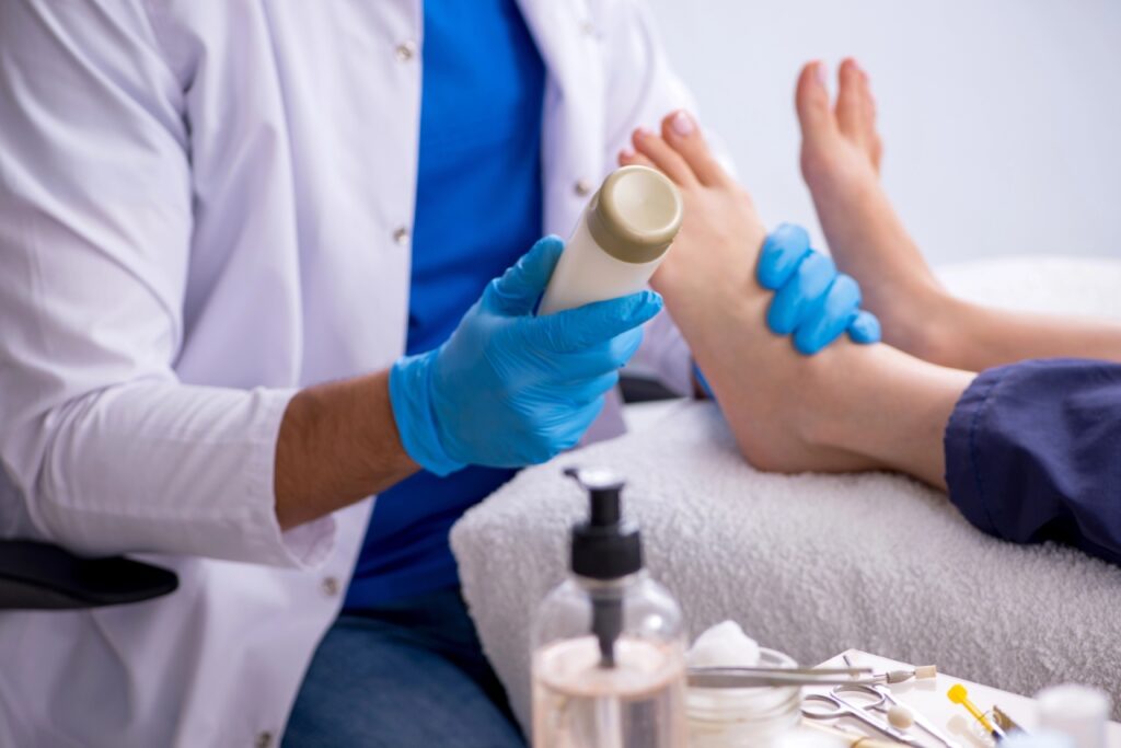 A Blue Cross Blue Shield podiatrist Cypress professional applies medical cream during a clinical foot treatment session.