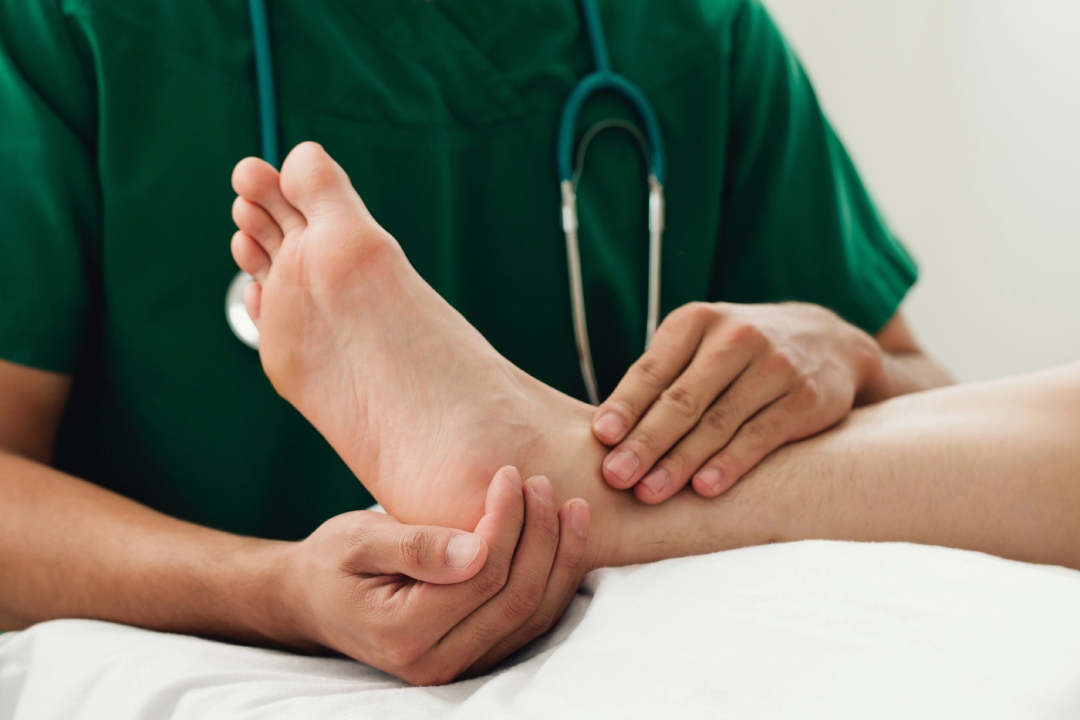 Experienced foot specialist doctor Cypress examining a patient's ankle and heel to diagnose chronic joint foot pain.