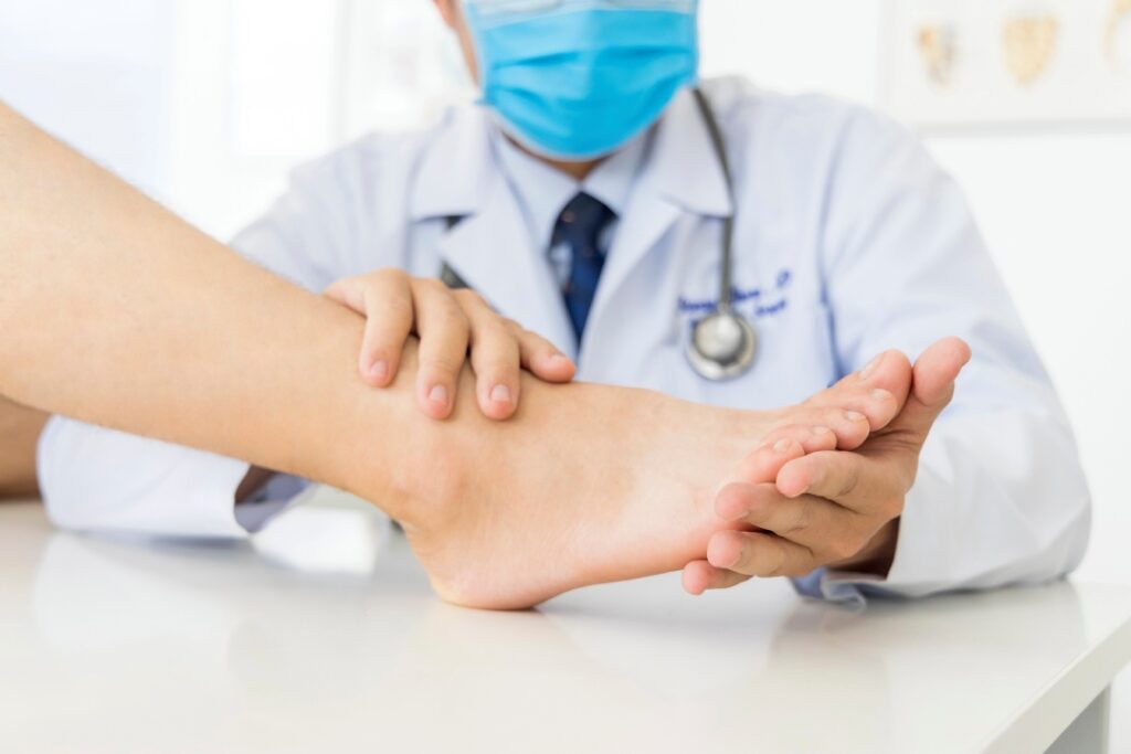 A foot specialist doctor Cypress performs a clinical podiatry consultation on a patient's foot and lower ankle area.
