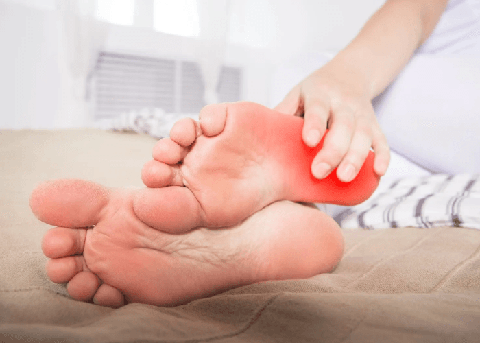Person holding a sore heel with red pain indicator for plantar fasciitis treatment Cypress patients often require.