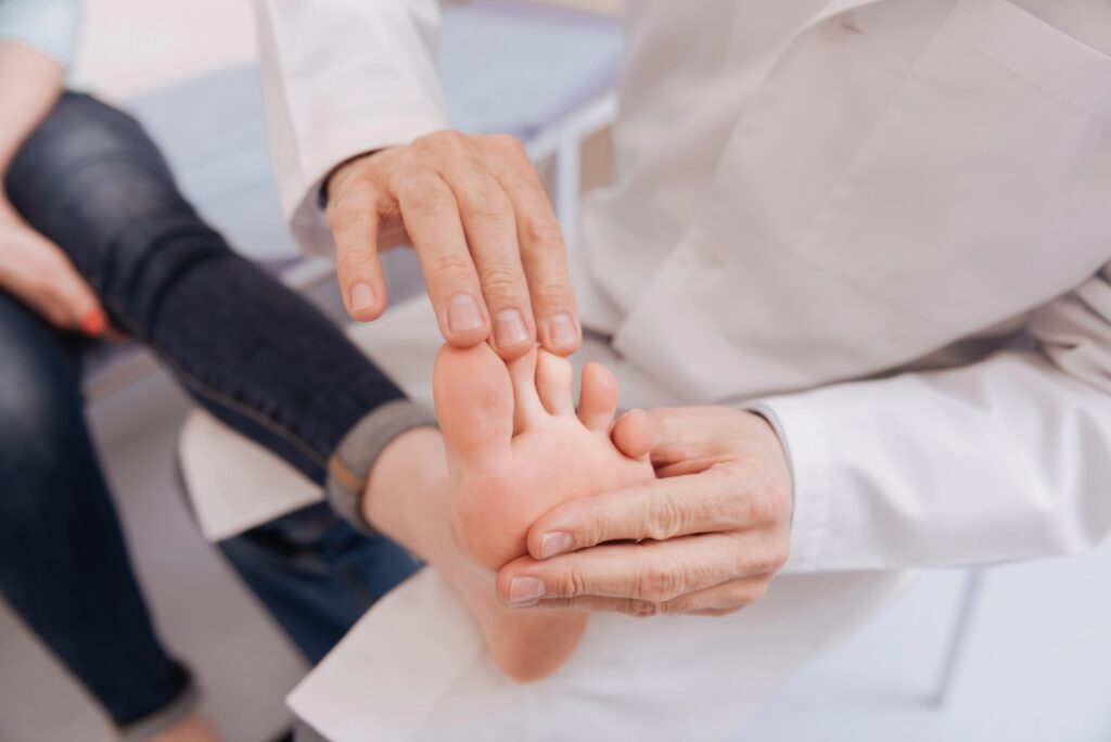 Medical professional performs a foot exam to determine if a patient is a candidate for qutenza treatment near me.